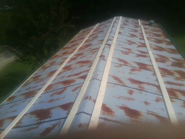 Rusted metal roof panels with new wood purlins before replacement — Storm Damage Roof Repair in Fresno by Roofing Brothers